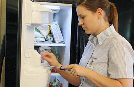 Technician fixing a fridge ice maker