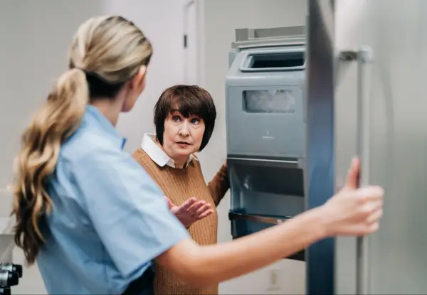 Woman and Mr.Appliance professional speaking in front of open fridge.