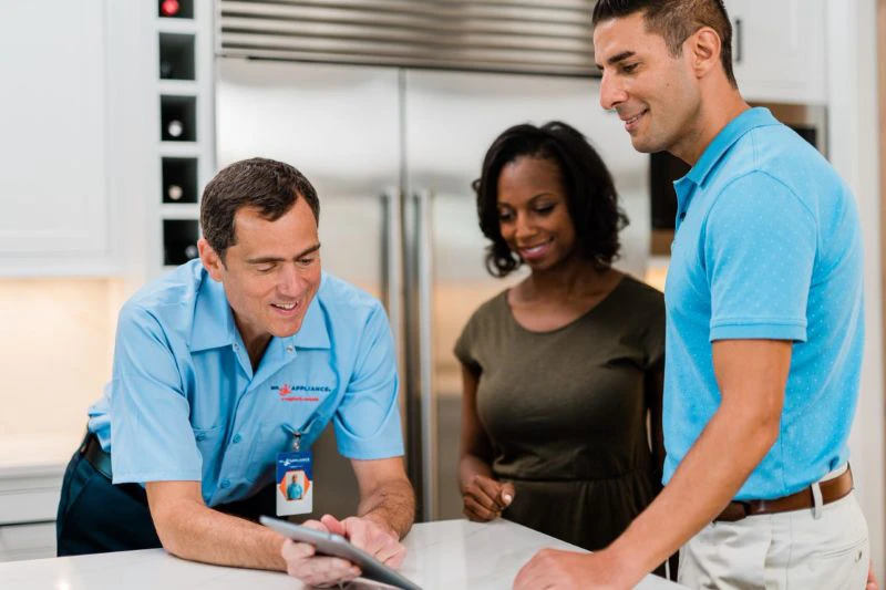 Mr. Appliance tech talking to a couple about dishwasher repairs